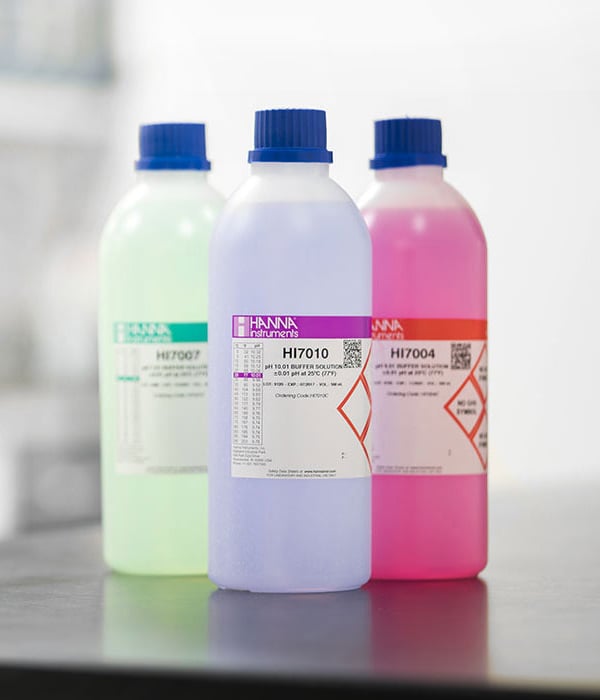 Three colorful bottles of buffer solutions.